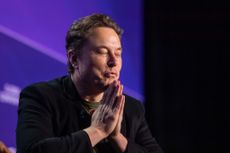 Photograph of Elon Musk with his hands together in front of him.