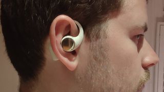 The Honor Earbuds Open in a man's ear.