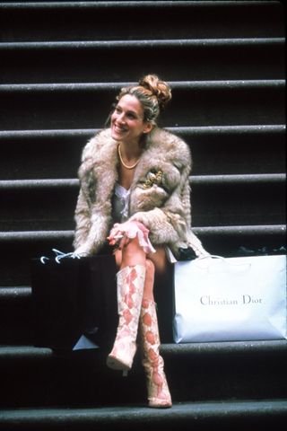 Carrie Bradshaw wearing fur coat and knee high boots