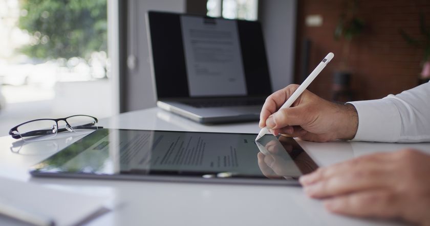 Digital document being signed on an iPad tablet with an Apple Pencil.