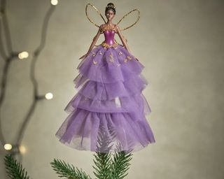 A black fairy Christmas tree topper with purple tulle skirt