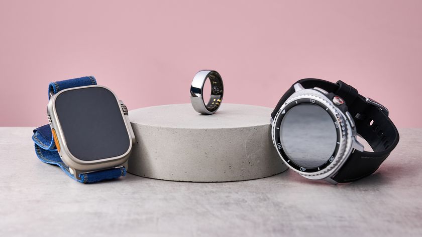 The Apple Watch Ultra 2 and Samsung Galaxy Watch 8 Classic sit either side of a stone podium, on which sits the Oura Ring 3.