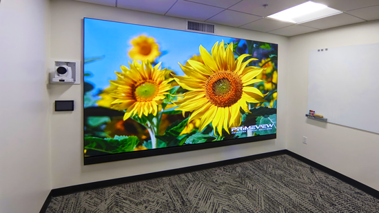 A videowall powered by Extron processors showing yellow flowers against a bright blue sky.