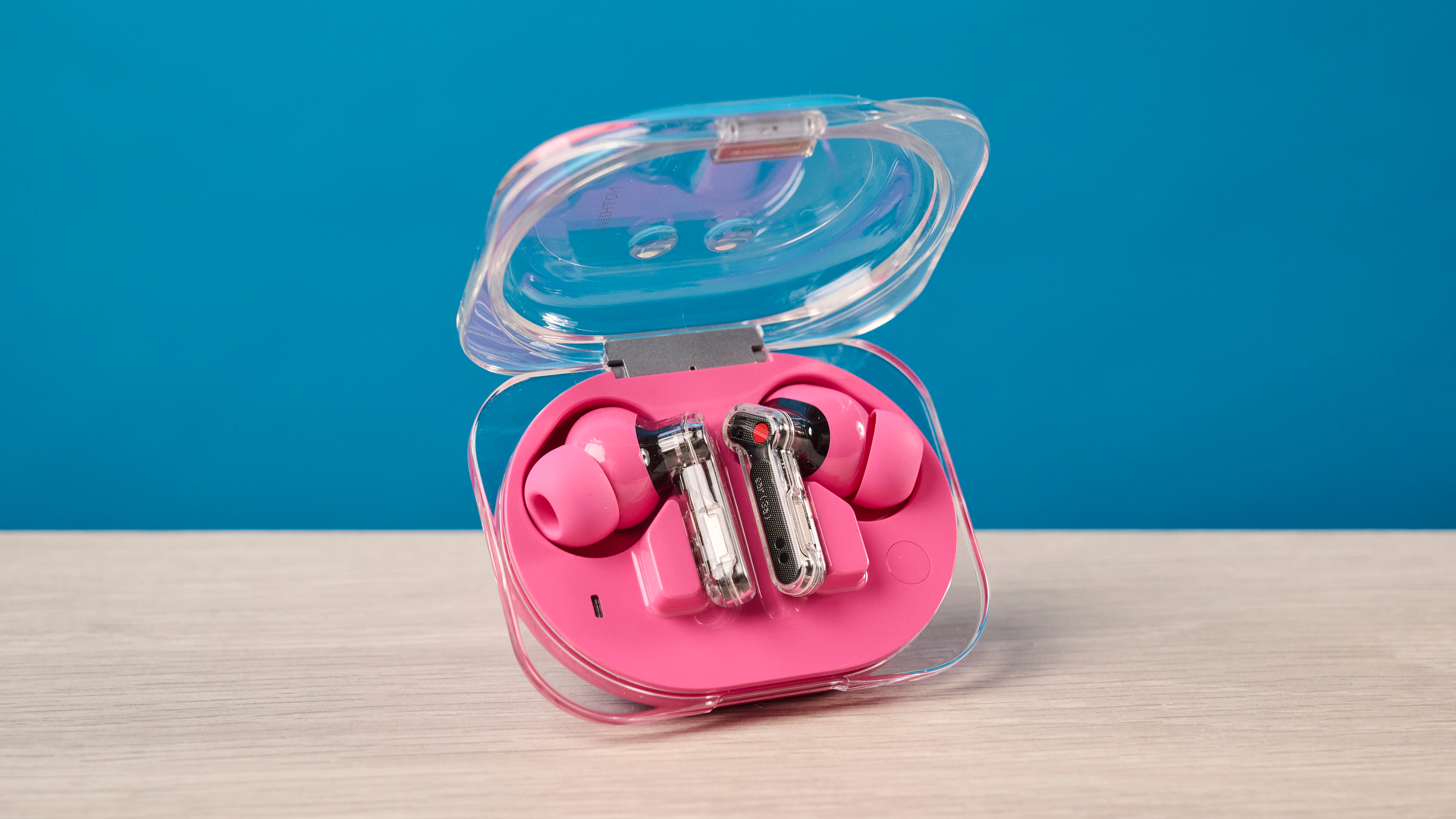 The Nothing Earbuds (3a) in pink, on a wooden surface