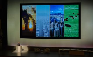 Lord Foster and a slide with four images of pollution, traffic jams, cityscapes and countryside