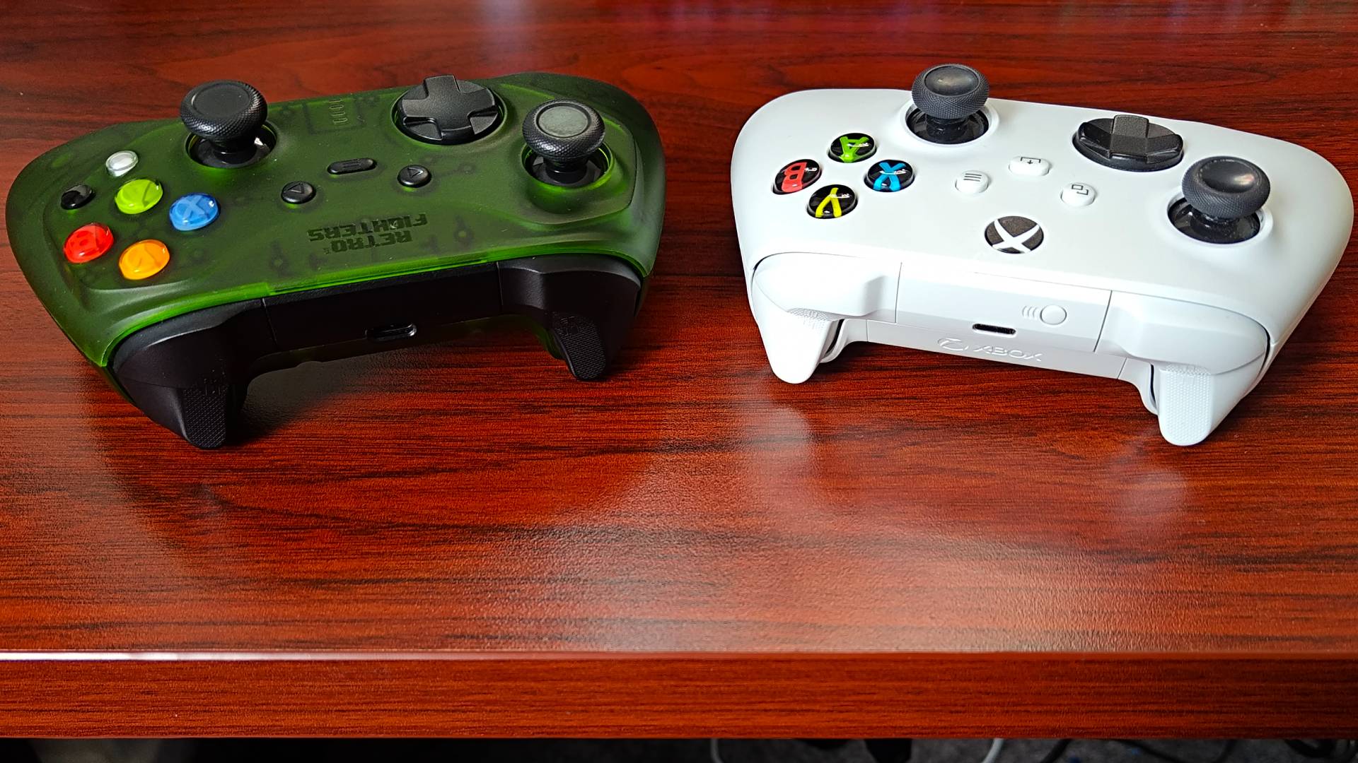 Retro Fighters Hunter and Xbox Wireless Controller in Robot White on woodgrain desk with top USB-C ports and triggers facing forward.