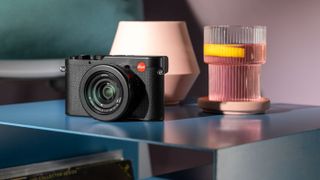 The Leica D-Lux 8 camera in black, in a colorful living room setting