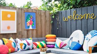 Backyard patio ideas: An image showing colorful outdoor cushions used to inject personality into a grey seating area