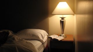 A lamp on a nightstand is a source of light pollution in a bedroom at night and can disrupt sleep and lead to frequent wakings