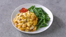 Plate of food, yellow mac and cheese, green beans and cherry tomatoes on gray stone counter