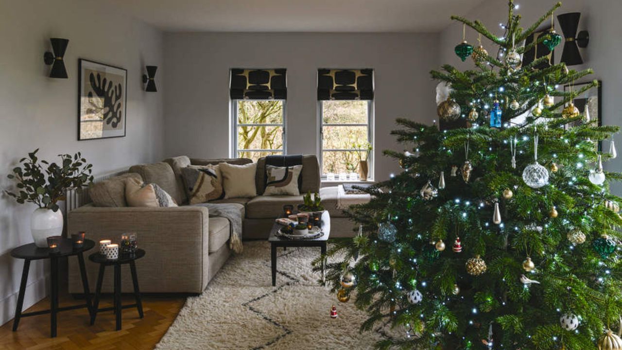 A well-decorated Chriistmas tree in a neutral living room