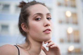 photo of a woman holding her chin with a blurred background