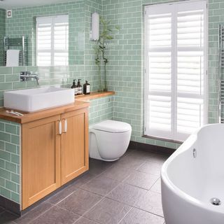bathroom with tiles all over and wooden counter