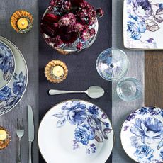 dinnerware with blue flower plates, candle lamps and glasses