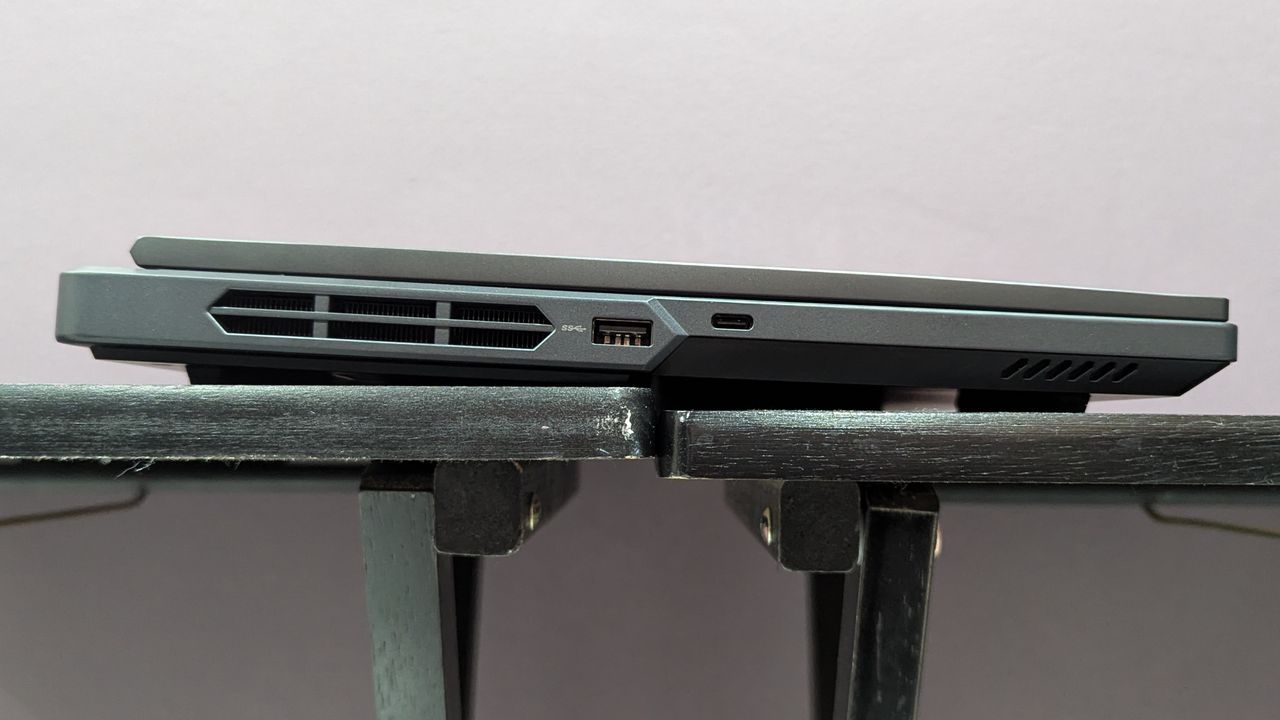 Lenovo Legion Pro 5i closed on a black table, highlighting the ports on the left, including USB Type-A and USB Type-C.