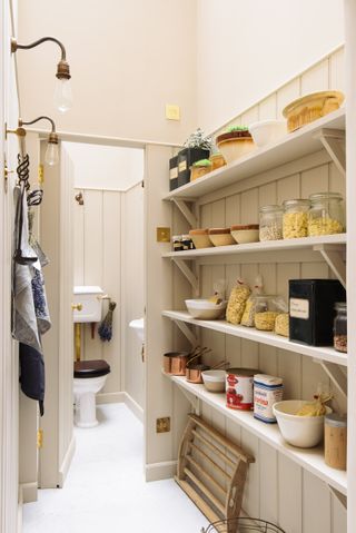 Cream walk-in butler's pantry with open shelving by deVOL