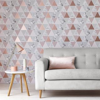 living room with grey sofa and rose gold wallpaper