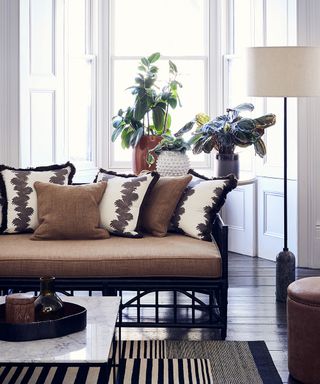 Global traveller style living room pictures showing a brown sofa with coordinating cushions and a monochrome rug.