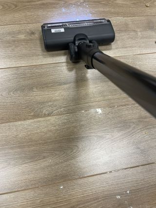 Tineco Pure One Station vacuuming flour and sugar on wooden floor