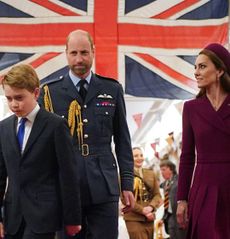 Prince George, Princess Kate and Prince William walking in front of a Union Jack
