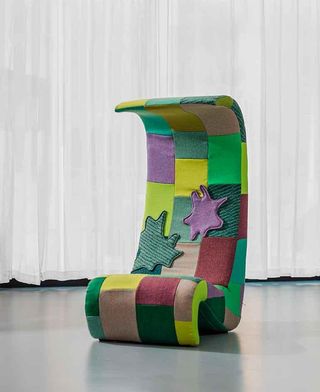 A highback chair in purple, yellow, red, and various shades of green upholstery.