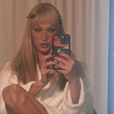 Bella Hadid getting ready with a block fringe hairstyle and hair clips in