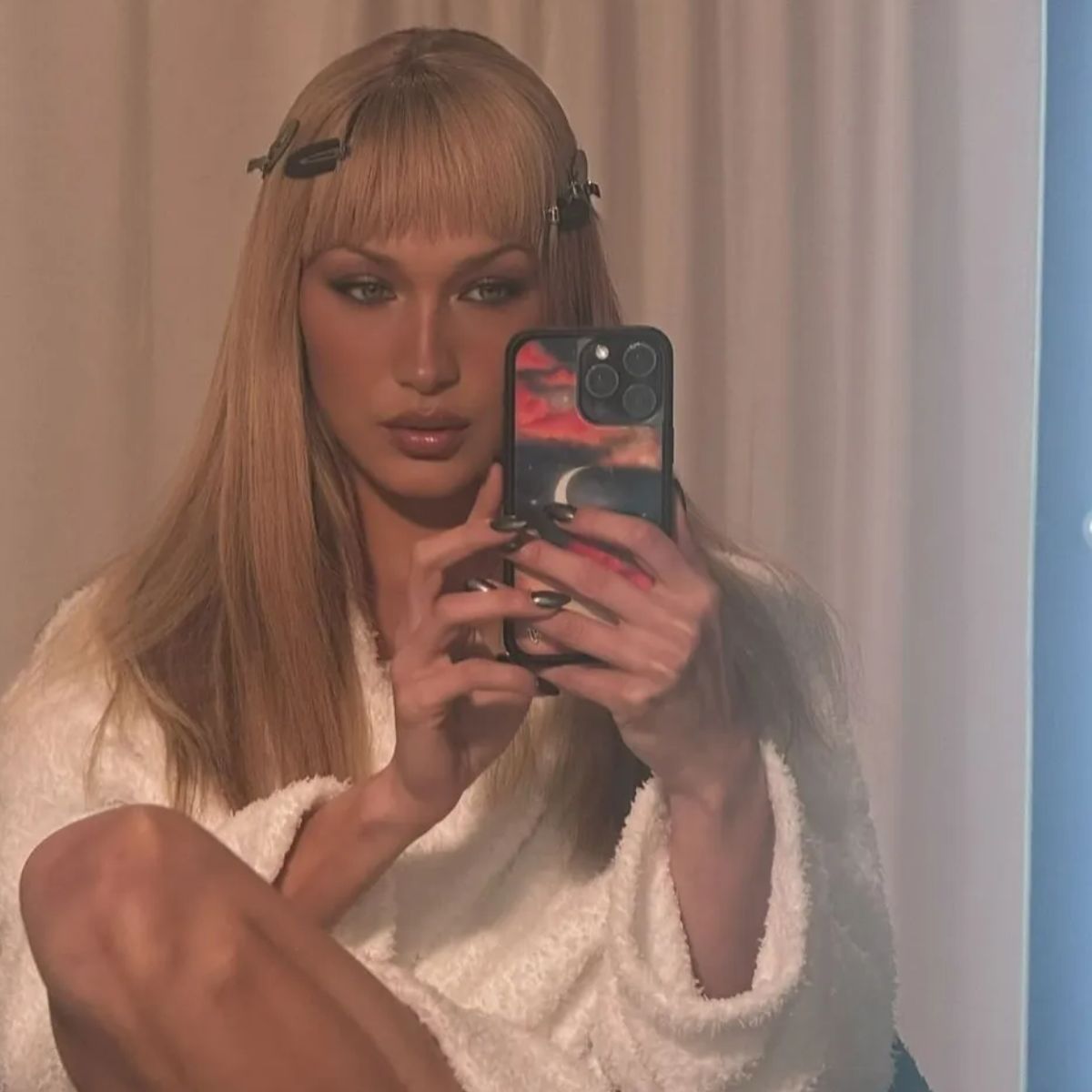 Bella Hadid getting ready with a block fringe hairstyle and hair clips in