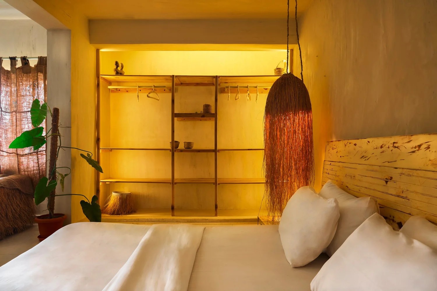 A texturally decorated hotel houses plenty of trailing plants, wooden furniture, and colorful and tactile art installations.