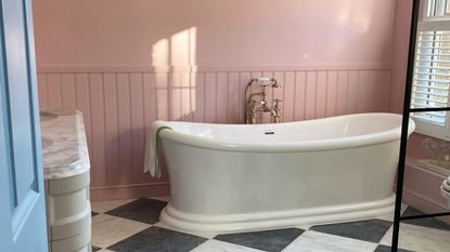 pink bathroom with pink walls and roll top bath