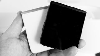 Two Samsung Galaxy Z Flip 7 FE devices in black and white closed in hand