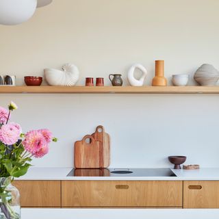 a Scandi-style kitchen with pale wooden cabinets and open shelving