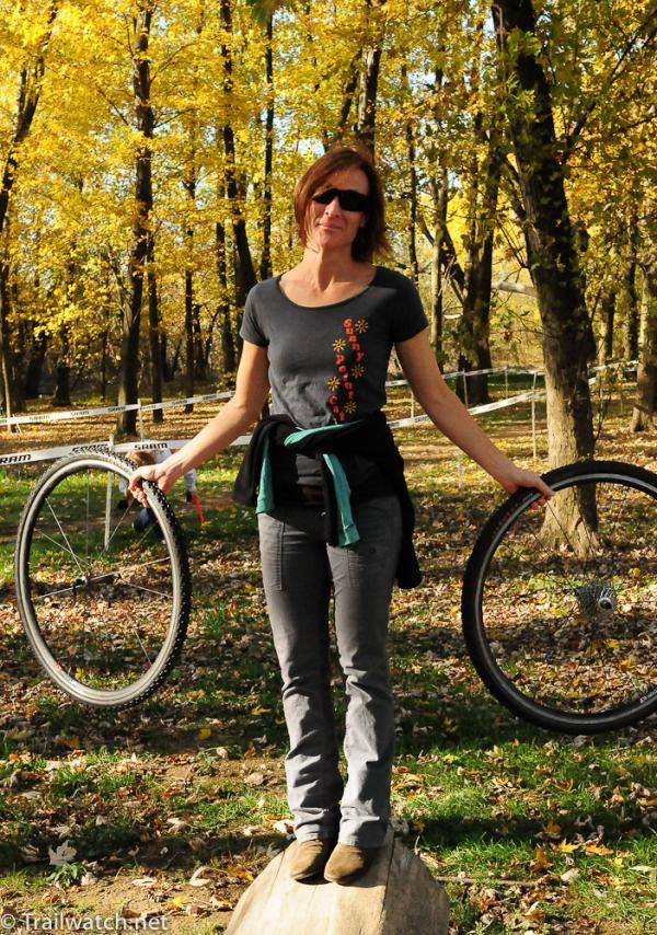A woman heads to the pits with her rider&rsquo;s wheels