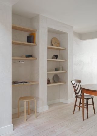 Reading desk made of blond wood shelves and small round stools