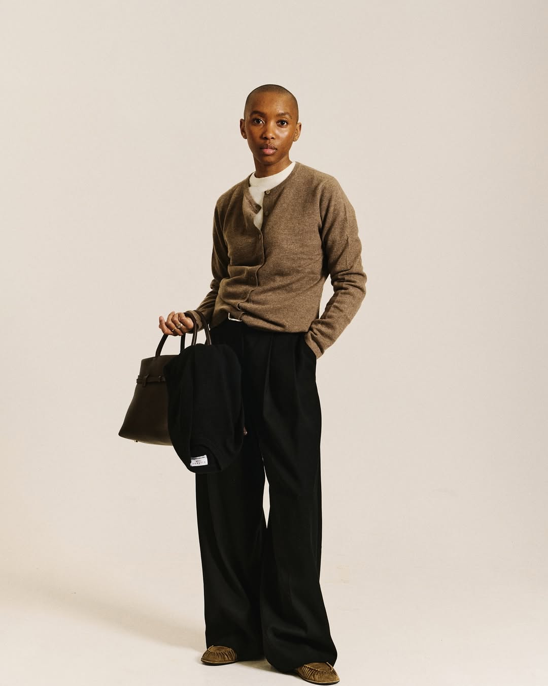 Black trouser outfits: @_marisamartins_ wears a cardigan with black tailored trousers