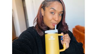 A person sipping out of a gold 40 Stanley Tumbler for Stanley Quencher Tumbler review.