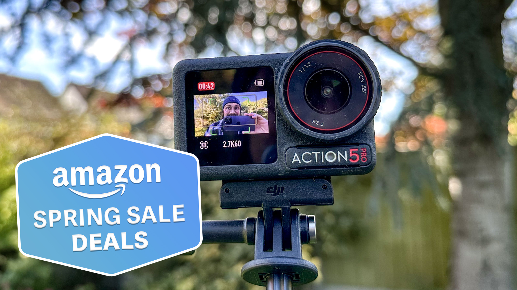 The DJI Osmo Action 5 Pro against a blurred background of trees and greenery, with a Tom's Guide Amazon Spring Sale badge in the lower left corner.