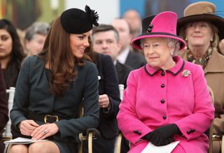 Queen Elizabeth II and Catherine, Duchess of Cambridge watch a fashion show at De Montfort University