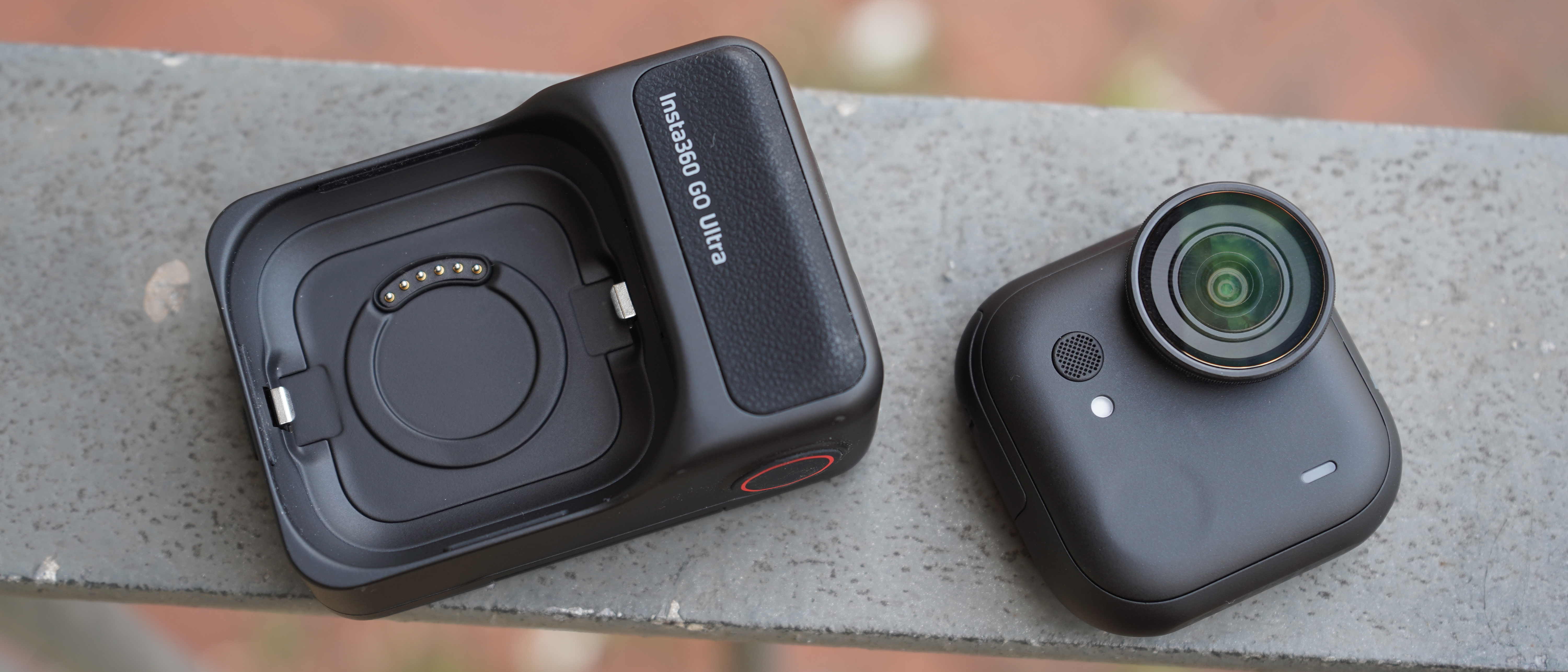 Insta360 Go ultra camera in two parts lying on a fence