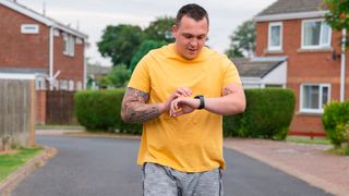 Man looks at his running watch