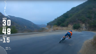 Tom pidcock cornering hard on a mountain road