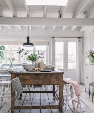 dining area in beach cabin with wooden clad vaulted ceiling and rooflight