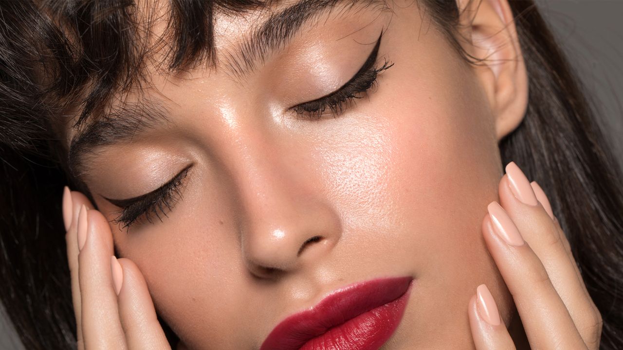 Close up studio shot of a beautiful woman with perfect skin, she touching her face