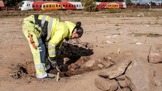 A woman excavates a grave site