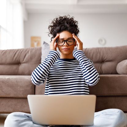 How to avoid burnout: A stressed woman sat holding her head