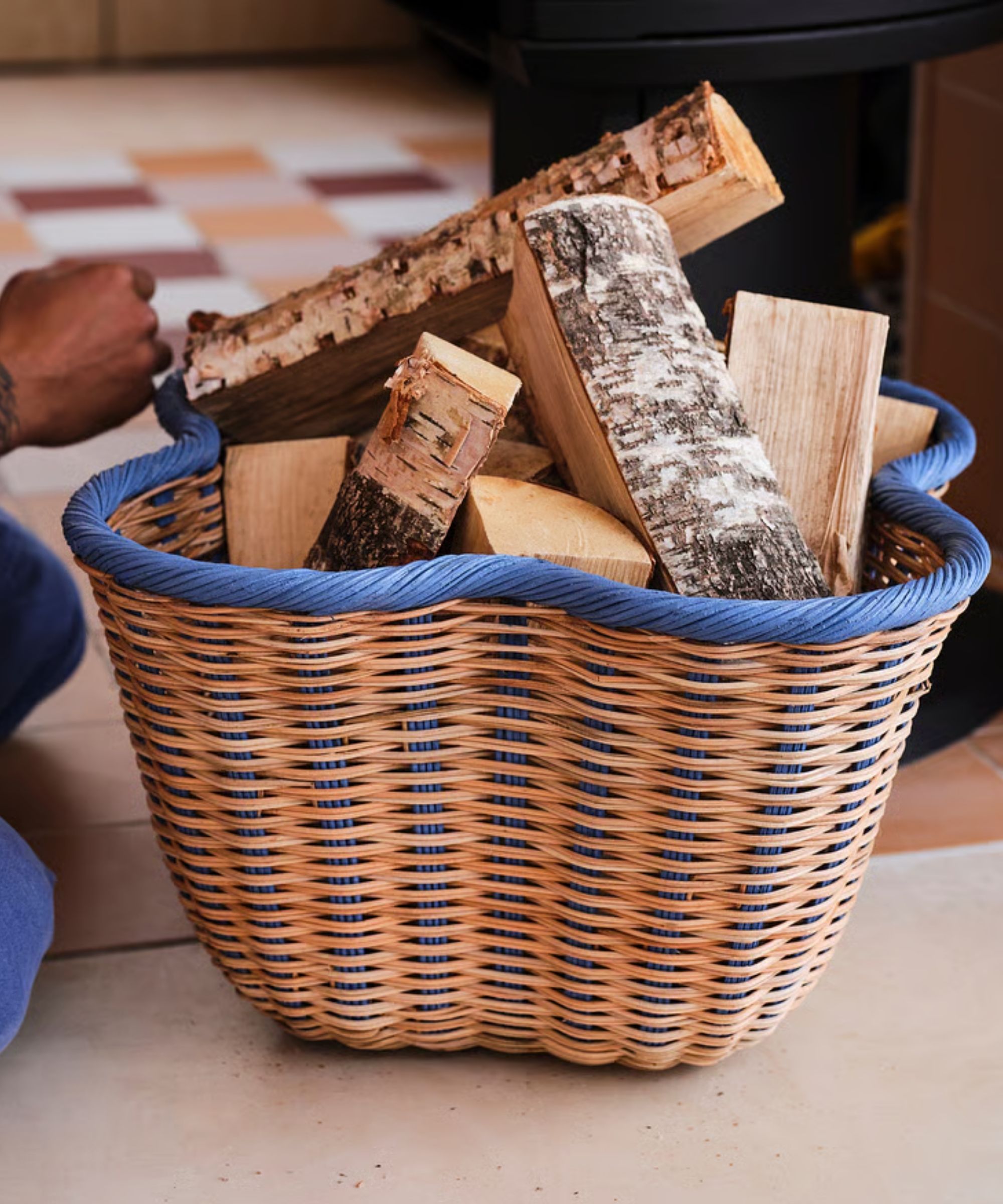 IKEA rattan basket with blue scalloped edge full of kindling