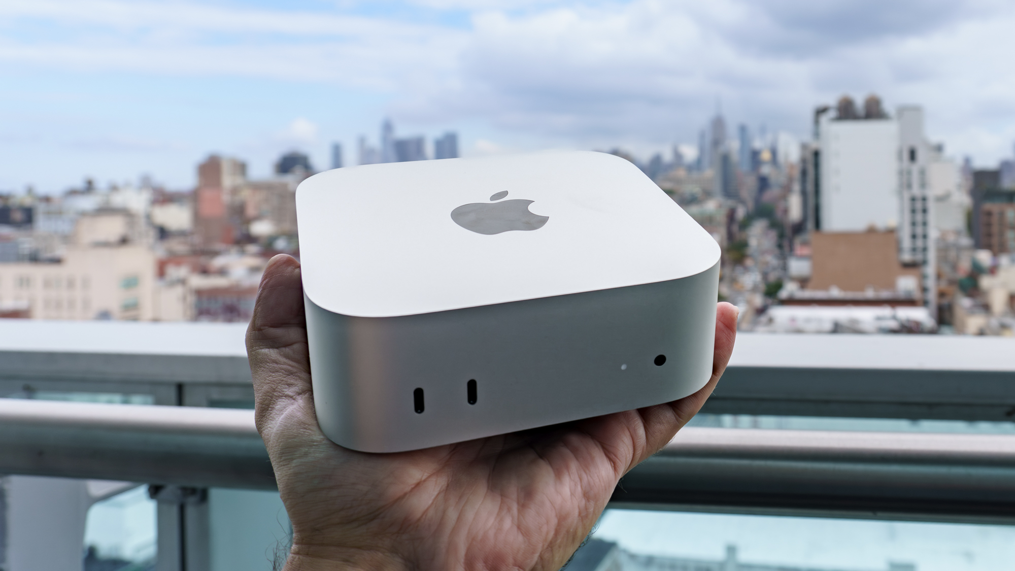 A person holding a Mac mini with M6 in hand