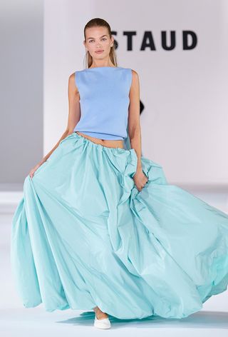a model on Staud's spring runway wearing a blue ballon maxi skirt with a matching boat neck top