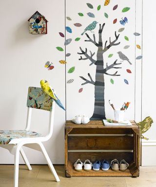 kids room with tree wallpaper and birdhouse with wooden shoe rack and painted chair
