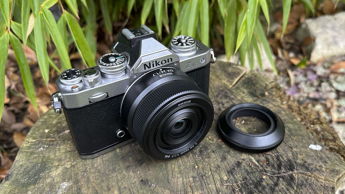 Nikkor Z DX 24mm f/1.7 lens mounted on a Nikon Z fc camera. The lens hood is off to one side.