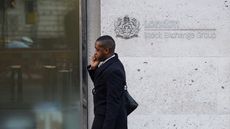 Man walking past the London Stock Exchange 